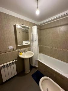 a bathroom with a sink and a tub and a toilet at Belgrano Ushuaia in Ushuaia