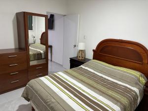 a bedroom with a bed and a dresser and a mirror at Apto comodo, muy cerca de playa 101 in Mazatlán