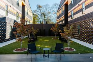 a courtyard with two chairs and a table and trees at The Vinyl at Music Row - 1 Bedroom Apartment in Nashville