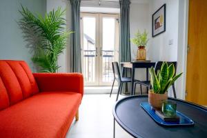 a living room with a orange couch and a table at Great location Modern refurbishment Free parking in Leeds