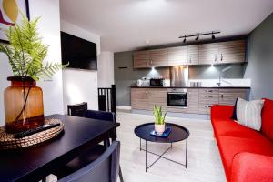 a living room with a red couch and a table at Modern townhouse City Location Free parking in Leeds +10 photos
