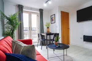 a living room with a red couch and a table at Great location Modern refurbishment Free parking in Leeds