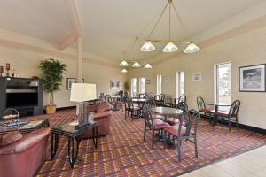 a living room with tables and chairs and a couch at Super 8 by Wyndham Casper West by the River in Casper