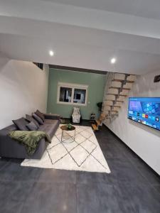 sala de estar con sofá y TV grande en Duplex-Cocon-Proximité - Piscines Thermales -Sauna, en Hombourg-Haut