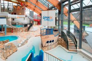 a large indoor pool with a pirate ship in a building at Duplex-Cocon-Proximité - frontières in Hombourg-Haut