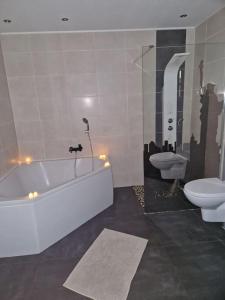 y baño con bañera blanca y aseo. en Duplex-Cocon-Proximité - Piscines Thermales -Sauna, en Hombourg-Haut