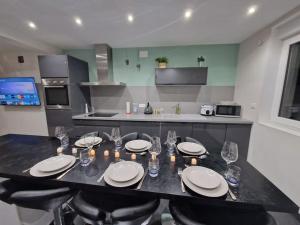 una cocina con una mesa con platos y velas. en Duplex-Cocon-Proximité - Piscines Thermales -Sauna, en Hombourg-Haut
