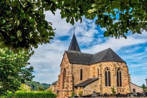 an old church with a steeple on a cloudy sky at Duplex-Cocon-Proximité - frontières in Hombourg-Haut