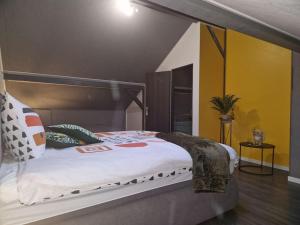 1 cama grande en un dormitorio con paredes amarillas en Duplex-Cocon-Proximité - Piscines Thermales -Sauna, en Hombourg-Haut
