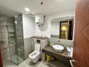 La salle de bains est pourvue de toilettes, d'un lavabo et d'une douche. dans l'établissement GOLD crest sunset luxury apartment, à Lahore