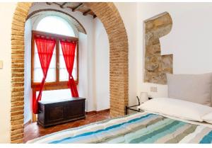 sypialnia z łóżkiem i oknem z czerwonymi zasłonami w obiekcie La Mezzana w mieście Santa Luce