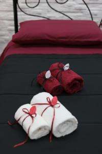 um animal de peluche vermelho e duas toalhas numa cama em B&B Imperial House in Pompei em Scafati