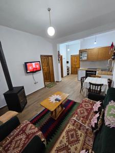 ein Wohnzimmer mit einem Sofa und einem Tisch in der Unterkunft Bujtinat Skenderi Gjinar in Gjinar