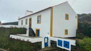 a white house with blue doors on a hill at Casa da Lapa in Angra do Heroísmo +28 photos