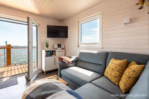 a living room with a couch and a tv at Hausboot Harmonie in Stralsund