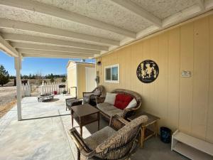 a patio with wicker chairs and a table and a couch at Sun Cabin #1 Pahrump in Pahrump