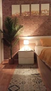 a bedroom with a brick wall with a bed and a lamp at La Sal Home Toledo in Toledo