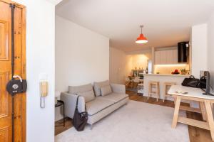 Una sala de estar con un sofá y una cocina. en River Breeze in Almada Velha, en Almada
