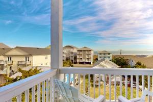 a balcony with chairs and a view of condos at Blue Oasis in Carolina Beach