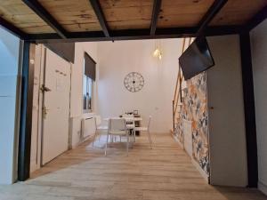 a dining room with a table and a clock on the wall at Mediodia Chica apartamento tipo loft en La Latina in Madrid