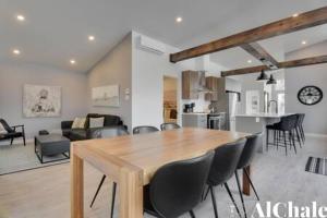 a dining room and living room with a table and chairs at Archibald - Cozy avec spa, sauna, piscine in Pont-Rouge