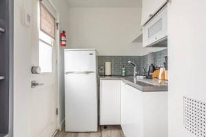 a white kitchen with a refrigerator and a sink at AMAZING Hermosa Beach Location Free Parking in Hermosa Beach