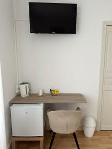 a desk with a chair and a television on a wall at Au Wachtfels in Obersteinbach +30 photos