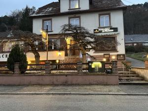 a white house with a fence in front of it at Au Wachtfels in Obersteinbach