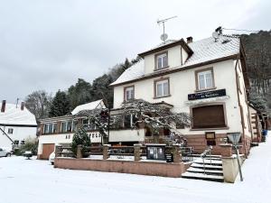 a building in the snow in front at Au Wachtfels in Obersteinbach