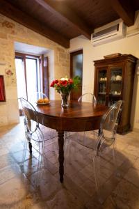 a wooden table with chairs and a vase of flowers on it at CASA RITELLA in Castellana Grotte +9 photos