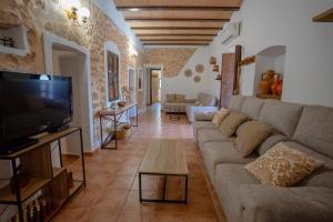 Una sala de estar con un sofá y un televisor de pantalla plana. en Casa Rural Can Blaiet, en La Mola