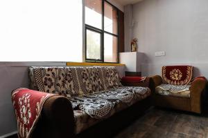 OYO Nabhyansh Elite في إندوري: غرفة معيشة مع أريكة وكرسي