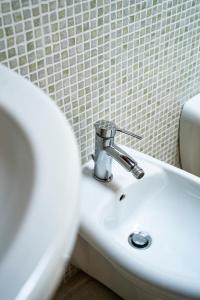 a white sink in a bathroom next to a toilet at CASA RITELLA in Castellana Grotte