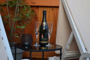 a bottle of wine on a table with two glasses at Domaine des Trois Sorciers in Bouxwiller