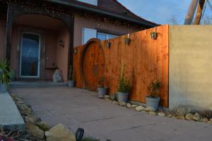 a fence next to a house with a wooden door at Domaine des Trois Sorciers in Bouxwiller