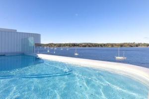 a swimming pool with a view of the water and boats at Magnificent 1-Bed with BBQ and Views in Batemans Bay