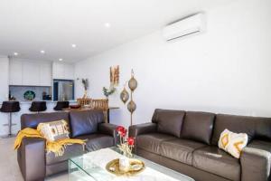 a living room with a couch and a glass table at Magnificent 1-Bed with BBQ and Views in Batemans Bay