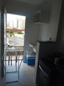 ein Bad mit einem Waschbecken, einem WC und einem Fenster in der Unterkunft Apartamento 2 quartos próximo da praia in Praia Grande