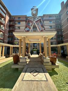 ein Gebäude mit einer Uhr darüber in der Unterkunft APART SUN Travel SUNNY BEACH in Sonnenstrand