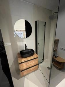 ein Bad mit einem schwarzen Waschbecken und einem Spiegel in der Unterkunft Suite PLAYAMAR con jacuzzi in Torremolinos