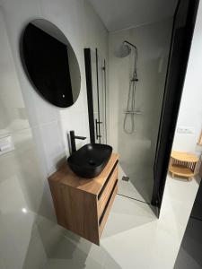 ein Bad mit einem Waschbecken, einer Dusche und einem Spiegel in der Unterkunft Suite PLAYAMAR con jacuzzi in Torremolinos