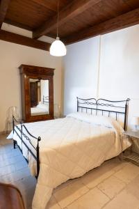 een slaapkamer met een groot bed en een spiegel bij CASA RITELLA in Castellana Grotte