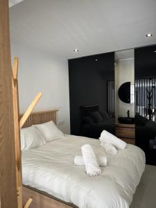 Una cama blanca con toallas encima. en Suite PLAYAMAR con jacuzzi, en Torremolinos