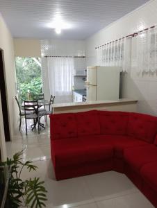 un salon avec un canapé rouge et une cuisine dans l'établissement Flor da serra, à Santo Antônio do Pinhal 11 autres photos