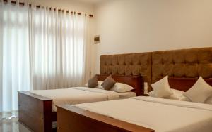 コスゴダにあるPiyum Villa Kosgodaのベッドルーム1室(ベッド2台、大きな窓付)