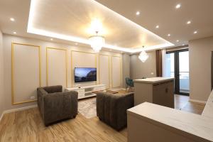 sala de estar con 2 sillas y TV en Grandstay Apartments, en Durrës