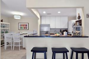 a kitchen with a counter and stools in a kitchen at Ocean Walk E-5 in Saint Simons Island