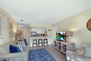 a living room with a couch and a tv at Ocean Walk E-5 in Saint Simons Island
