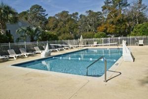 a large swimming pool with chairs and a fence at Ocean Walk E-5 in Saint Simons Island