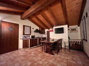 a kitchen and dining room with a table and a refrigerator at Casa Rilassa Monte in Cividale del Friuli